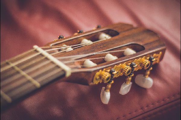 just4uentertainment image of the head of a classic guitar on leather background